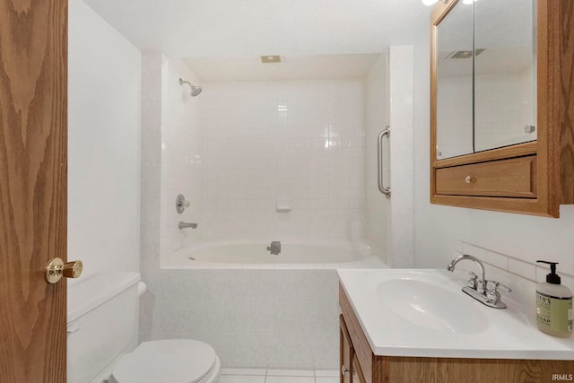 full bathroom featuring tile patterned floors, vanity, tiled shower / bath combo, and toilet