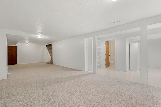 basement with light carpet and a textured ceiling