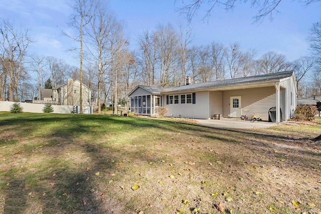 back of house featuring a sunroom, a yard, and a patio