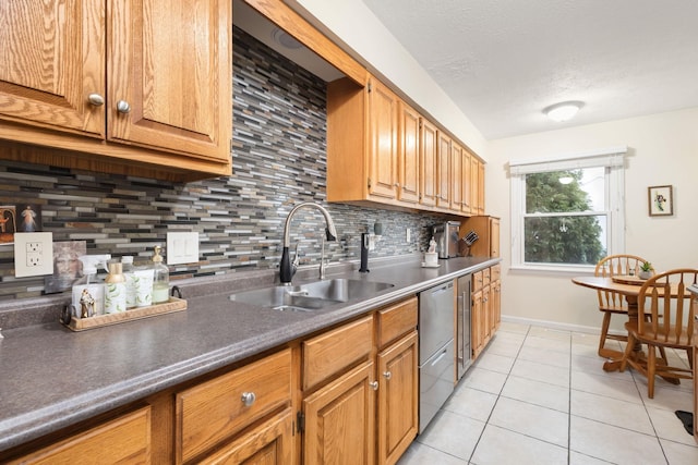 kitchen with decorative backsplash, stainless steel dishwasher, a textured ceiling, sink, and light tile patterned floors