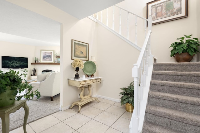 stairway featuring tile patterned flooring and a brick fireplace