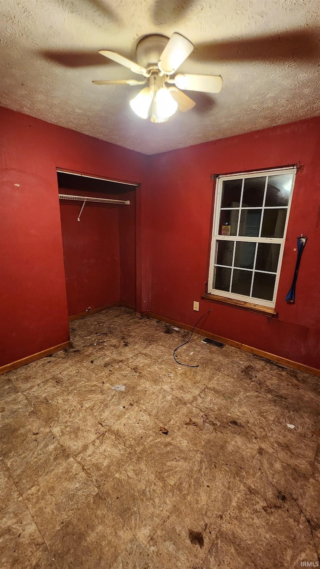 unfurnished bedroom with ceiling fan, a textured ceiling, and a closet