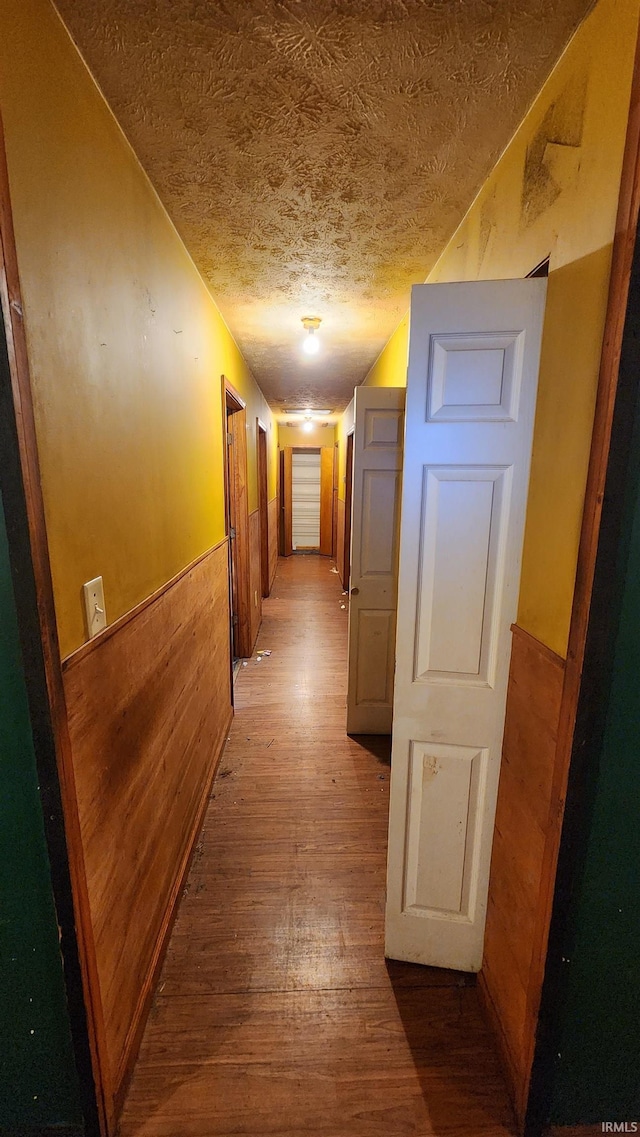 hall featuring hardwood / wood-style floors and a textured ceiling