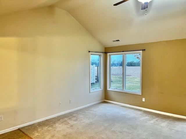 carpeted empty room featuring ceiling fan and vaulted ceiling