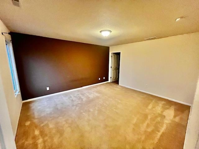 spare room featuring carpet floors and a textured ceiling