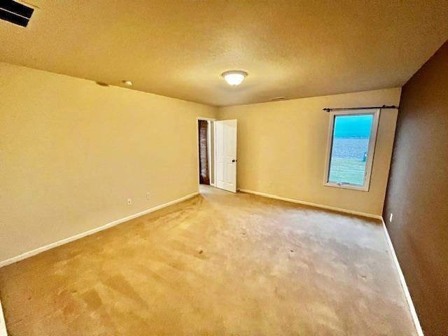 carpeted empty room with a textured ceiling and lofted ceiling