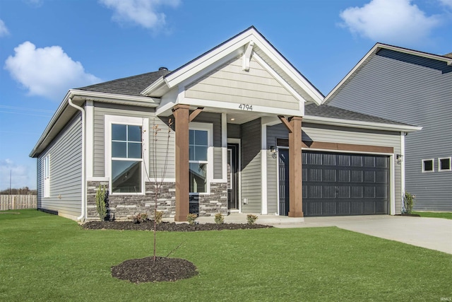 craftsman house featuring a garage and a front lawn