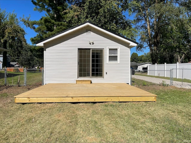 back of house with a deck and a lawn