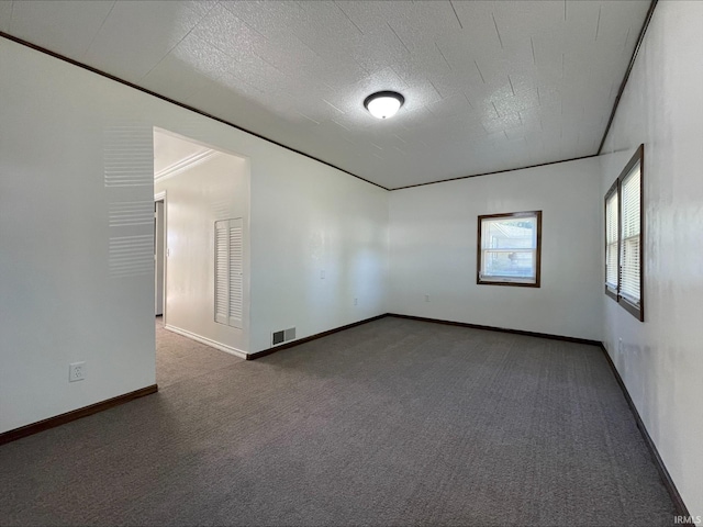 spare room with dark colored carpet and a textured ceiling