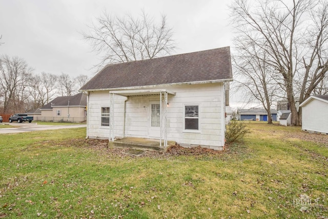 rear view of house featuring a lawn