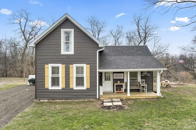 rear view of house featuring a porch and a lawn