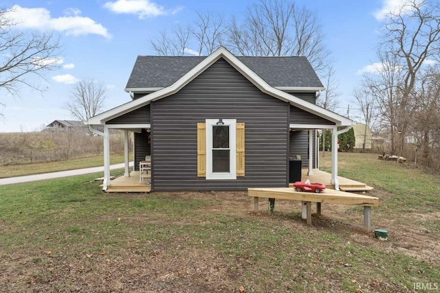 view of side of property with covered porch and a yard