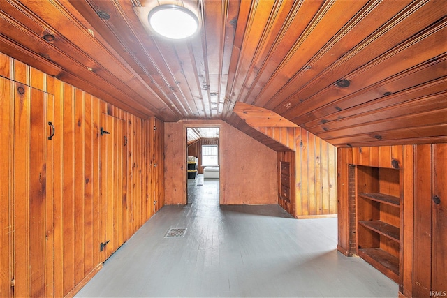 bonus room featuring lofted ceiling, wood ceiling, dark wood-type flooring, and wood walls