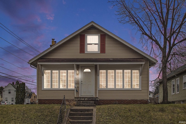 bungalow-style home with a yard