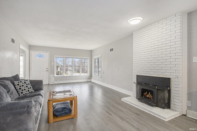 living room with a fireplace, a textured ceiling, and hardwood / wood-style flooring