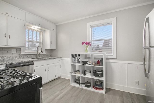 kitchen featuring light hardwood / wood-style flooring, white cabinets, a healthy amount of sunlight, and appliances with stainless steel finishes