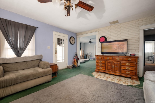 living room featuring carpet and brick wall