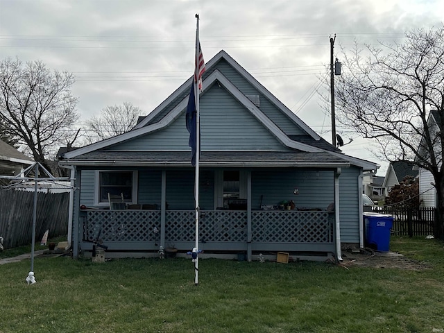 rear view of property with a porch and a lawn