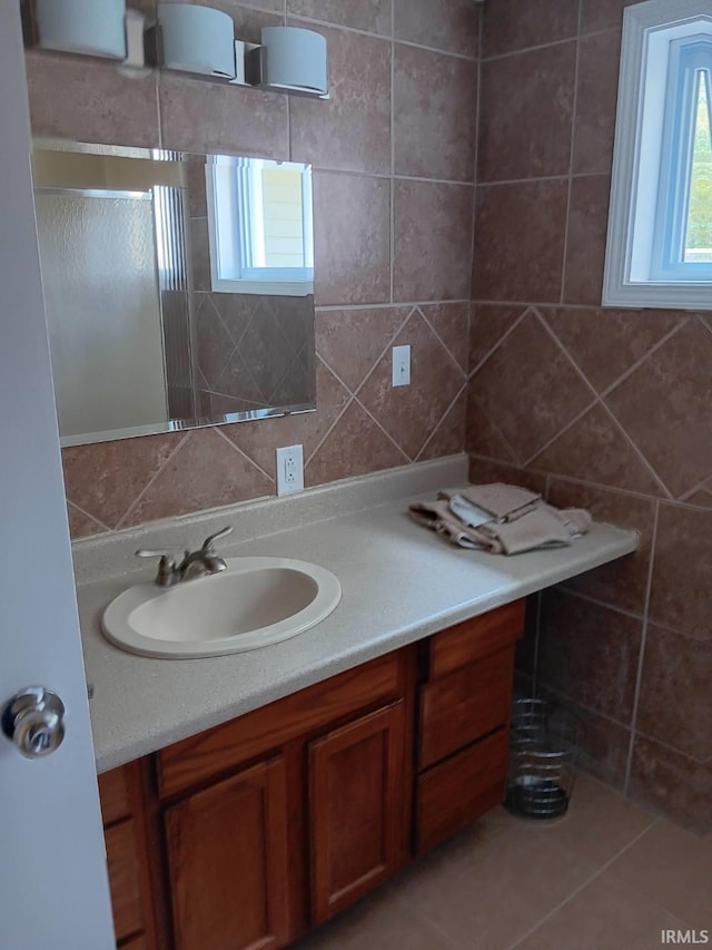 bathroom featuring tile patterned flooring, vanity, tile walls, and walk in shower