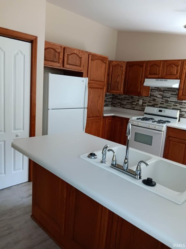 kitchen with white appliances, light hardwood / wood-style flooring, and backsplash