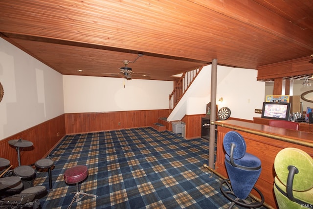 rec room featuring ceiling fan, wood walls, wooden ceiling, and indoor bar