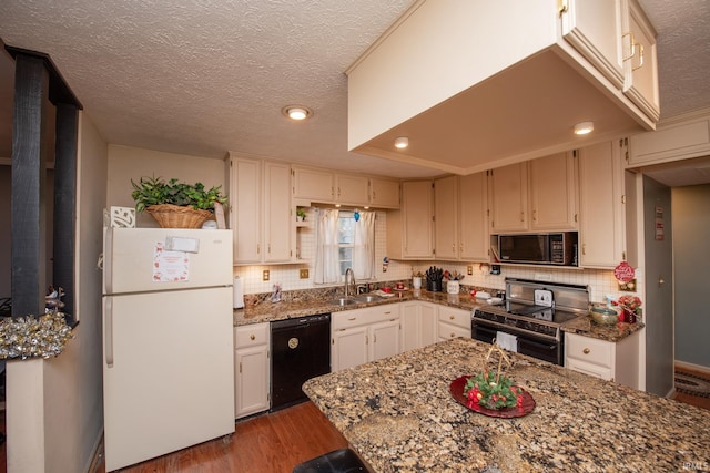 kitchen featuring sink, dark hardwood / wood-style flooring, stone countertops, and black appliances