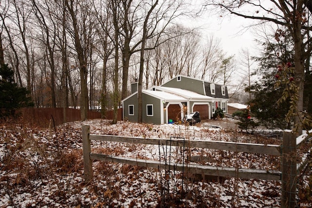 view of snowy exterior featuring a garage