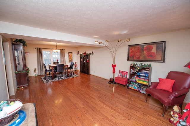 interior space with hardwood / wood-style floors, a textured ceiling, and an inviting chandelier