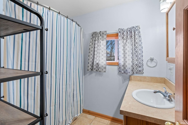 bathroom with tile patterned flooring, vanity, and walk in shower