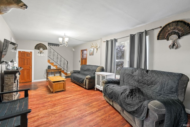 living room with an inviting chandelier and light hardwood / wood-style flooring