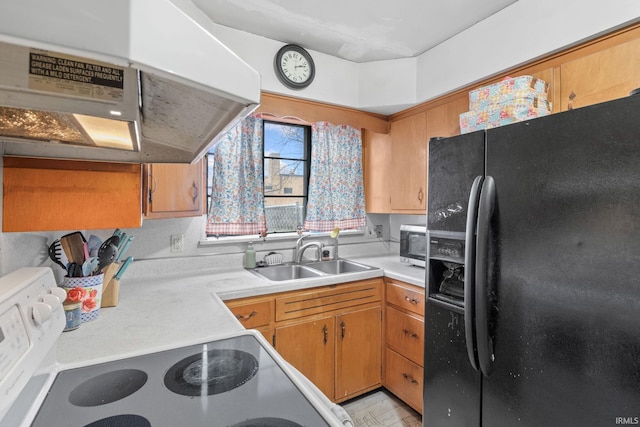 kitchen featuring black fridge, sink, exhaust hood, and range