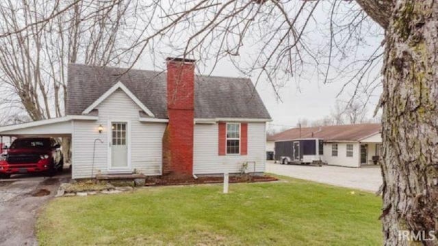 rear view of house with a carport and a lawn