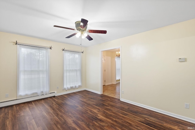 empty room with ceiling fan with notable chandelier, dark wood-type flooring, and a baseboard heating unit