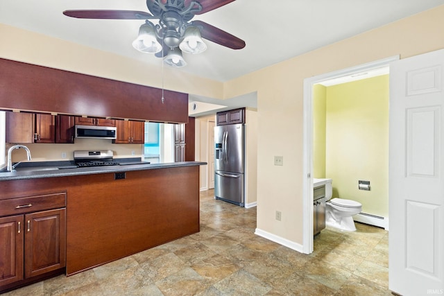 kitchen featuring sink, stainless steel appliances, baseboard heating, and ceiling fan