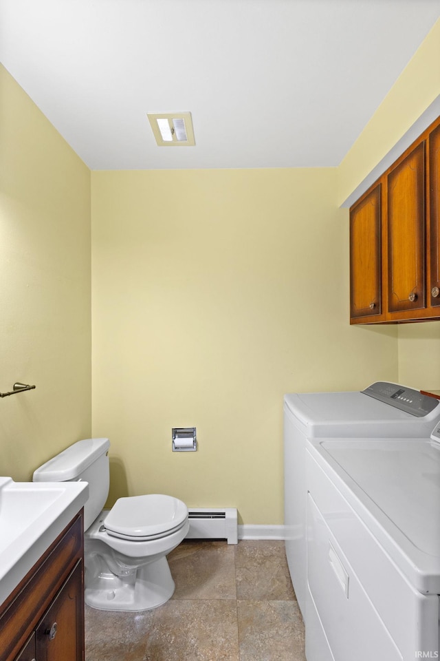 bathroom featuring baseboard heating, separate washer and dryer, vanity, and toilet