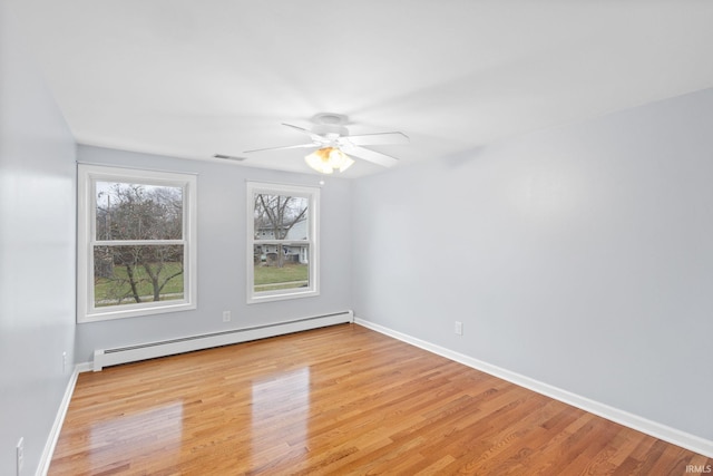 empty room with ceiling fan, light wood-type flooring, and baseboard heating