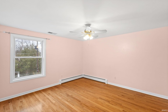 empty room featuring ceiling fan, light wood-type flooring, and baseboard heating