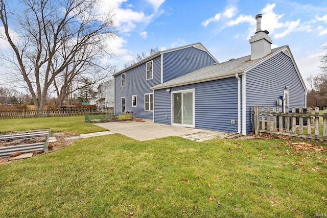 rear view of house featuring a yard and a patio