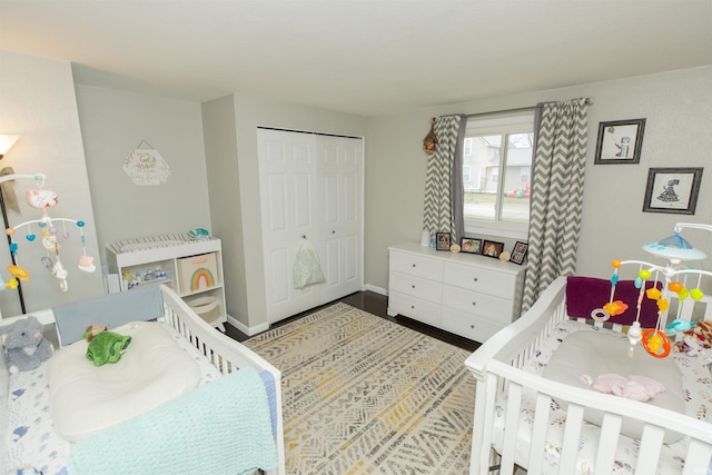 bedroom with hardwood / wood-style floors, a nursery area, and a closet