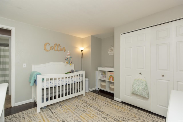 bedroom with hardwood / wood-style flooring, a nursery area, and a closet