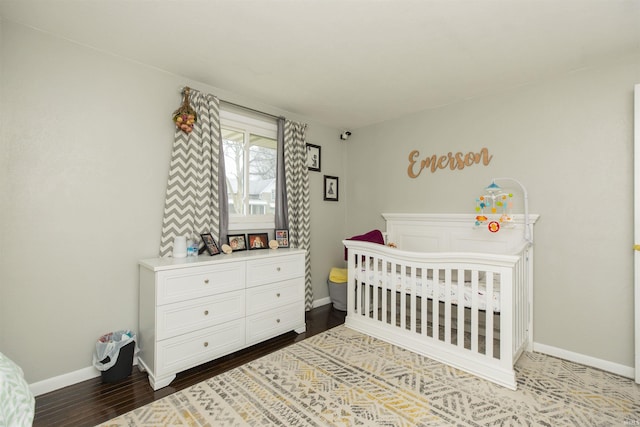 bedroom featuring a nursery area and wood-type flooring