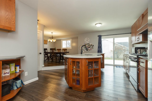 kitchen featuring stainless steel range with gas cooktop, sink, a chandelier, and dark hardwood / wood-style floors