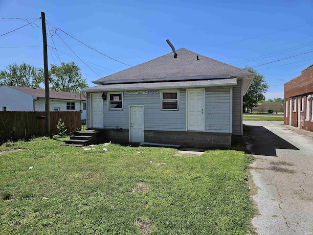 rear view of house featuring a lawn