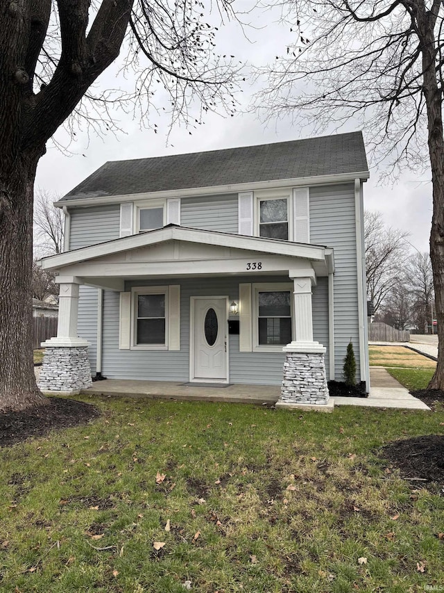 view of front of home with covered porch and a front lawn