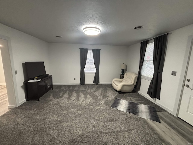 sitting room with dark wood-type flooring and a textured ceiling