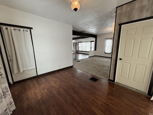 interior space with a textured ceiling, a baseboard radiator, and dark hardwood / wood-style floors