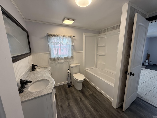 full bathroom featuring crown molding, wood-type flooring, toilet, shower / tub combination, and vanity