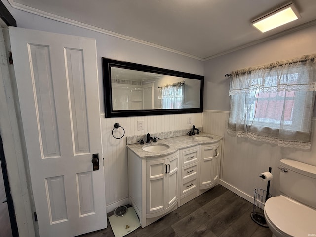 bathroom featuring hardwood / wood-style flooring, vanity, toilet, and crown molding