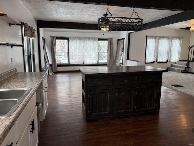 kitchen with sink, white cabinets, dark wood-type flooring, and a textured ceiling