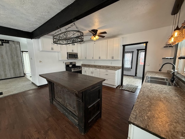 kitchen featuring stainless steel appliances, dark wood-type flooring, sink, beam ceiling, and white cabinets